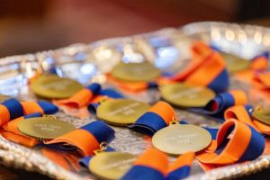 tray of gold medallions with orange and blue ribbon