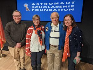 Four people stand smiling for a photo in front of a blue background that reads "Astronaut Scholarship Foundation." The people from left to right are Adam Crowley, Melissa Welshans, Col. Fred Gregory, and Jolynn Parker. 